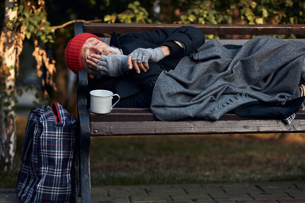 Poor vagrant on bench