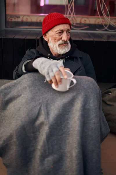 Hombre mendigo maduro con taza mendigando en la calle de la ciudad — Foto de Stock