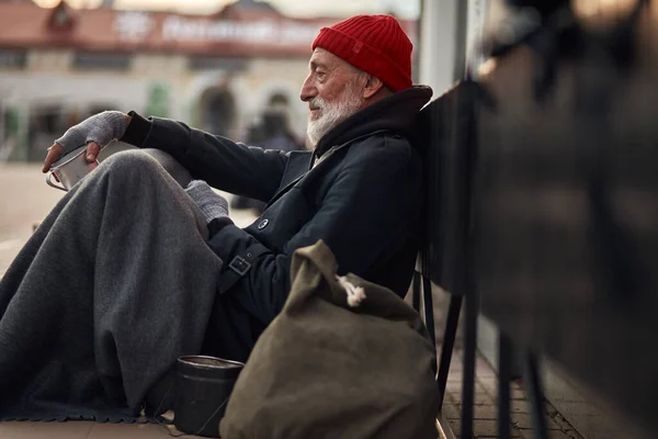 Bezdomovec čeká na pomoc. Nezaměstnaní žebráci žijí na ulici — Stock fotografie