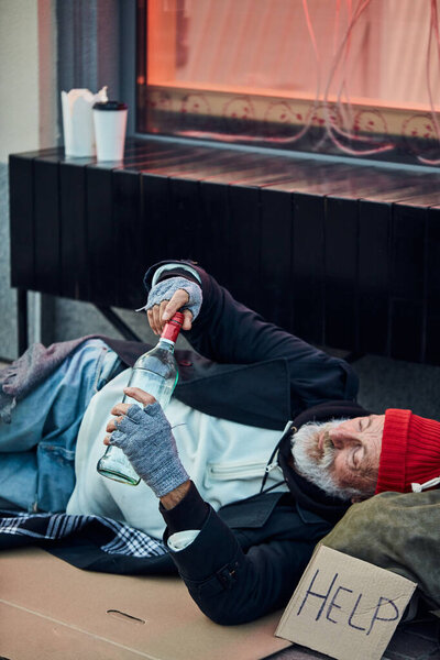 Beggar man lying on cardboard box