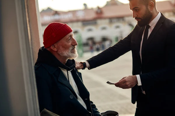 Rich man donate money to homeless — Stock Photo, Image