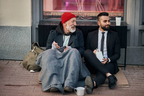 Feliz mendigo saludo con hombre de negocios en la calle — Foto de Stock