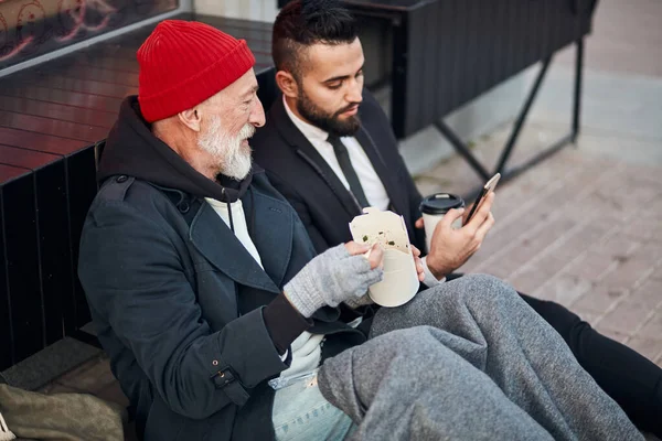 Interested beggar look at phone — Stock Photo, Image