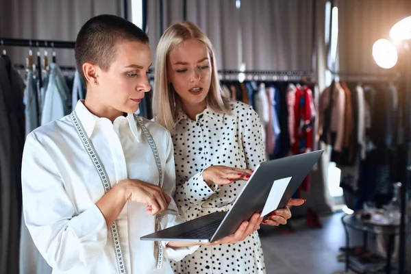 Young stylish women amazedly look at laptop