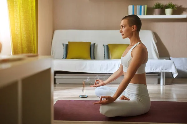 Портрет красивой женщины, тренирующейся дома, упражняющейся на коврике, медитирующей — стоковое фото