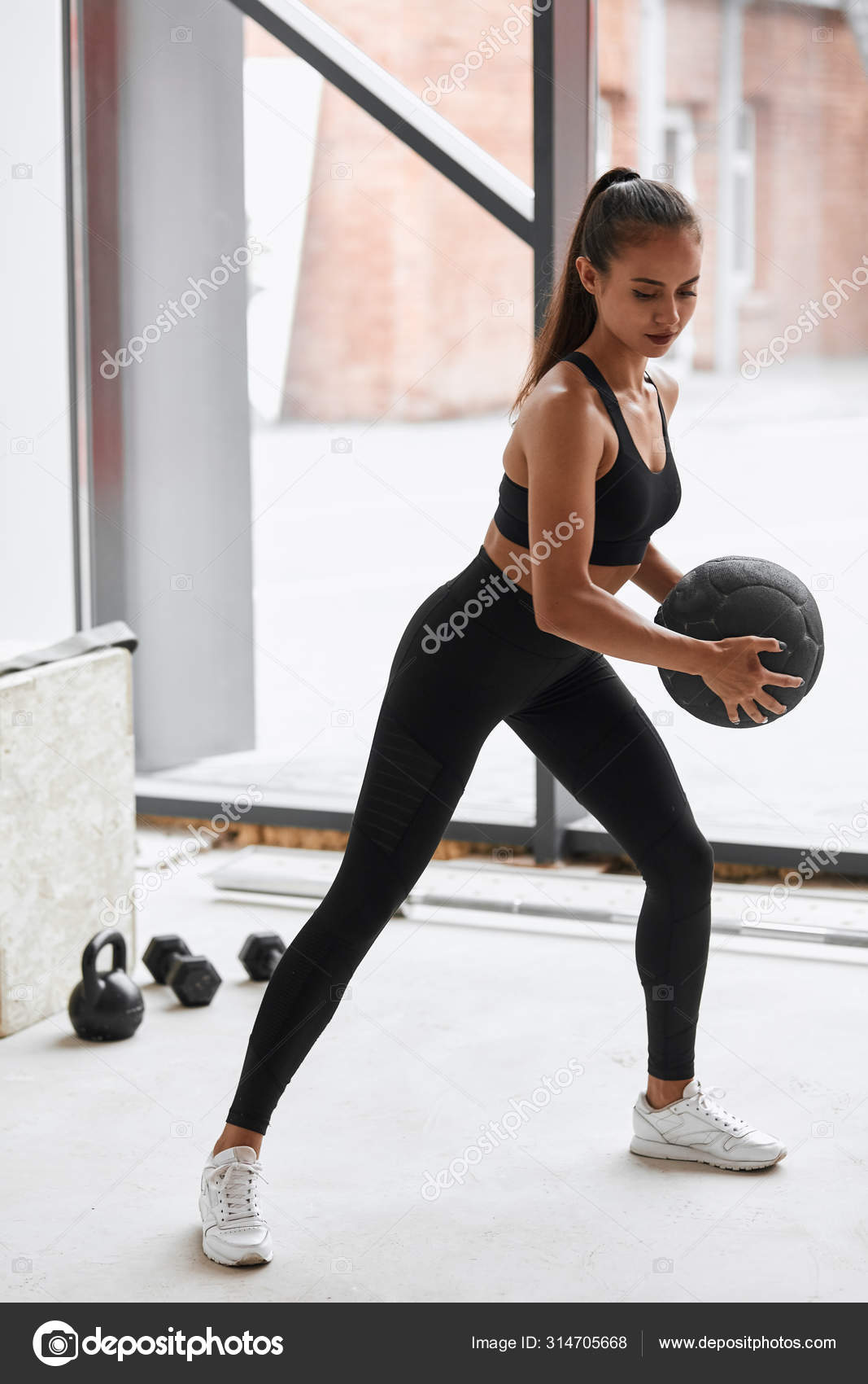 Fitness girl working out at white gym using ball Stock Photo by