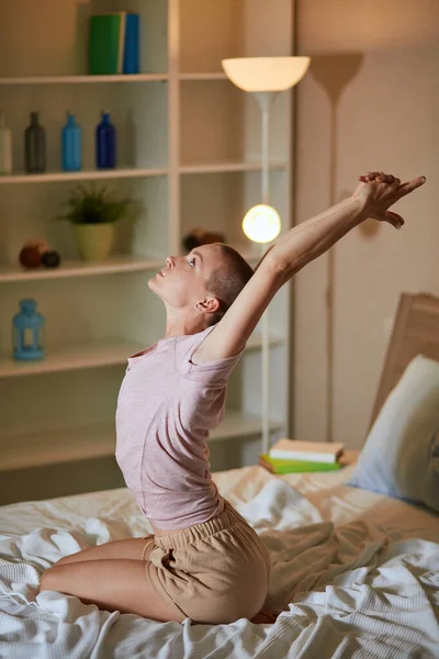 Morning of young woman doing yoga exercises in bedroom on bed. — Stock Photo, Image