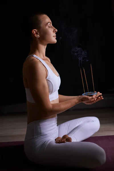 Jonge vrouw ontspannen met roken aromatische stokken. aromatherapie, meditatie — Stockfoto
