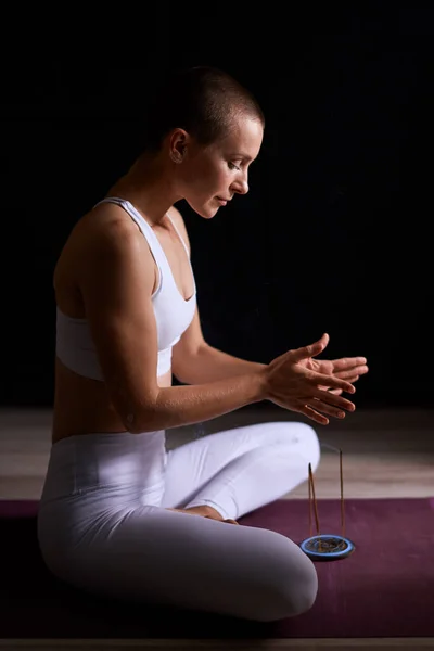 Медитирую дома. Кавказская женщина сидит перед ароматическими палочками — стоковое фото