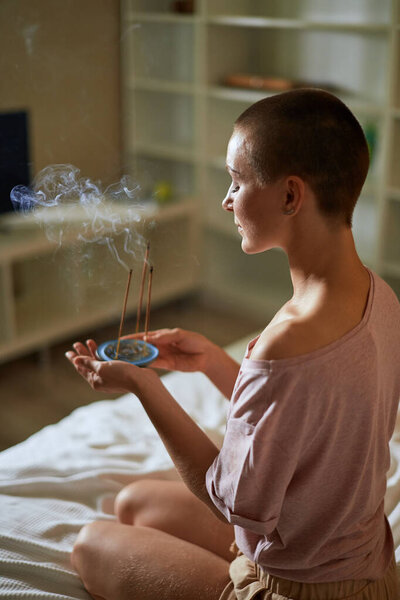 Attractive minfulness young woman enjoy incense sticks for yoga