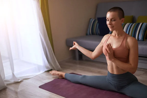 Mujer yogui en casa practicando yoga, haciendo splits — Foto de Stock