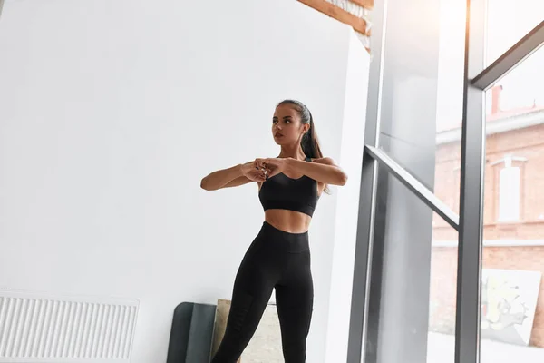 Mujer flexible en ropa deportiva negra hacer ejercicios —  Fotos de Stock