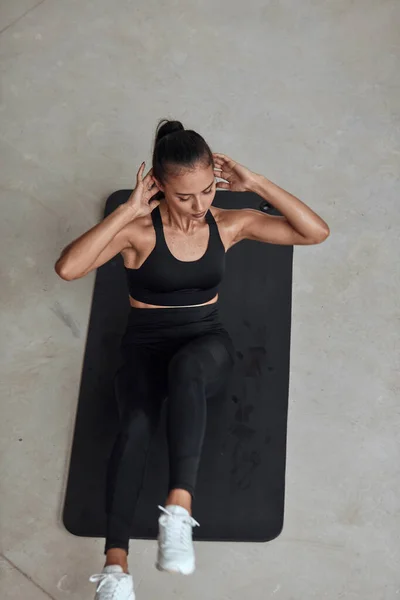 Fuerte fitness femenino bombeo en el gimnasio en la estera — Foto de Stock