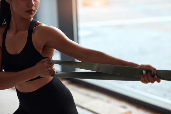 Joven mujer de fitness haciendo ejercicios con hondas en el gimnasio —  Fotos de Stock