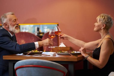 Olgun bir çift restoranda yemek yiyor.