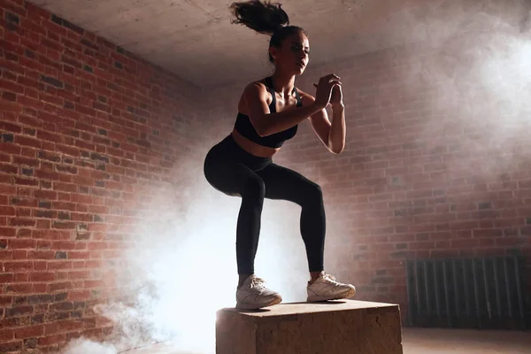 Mujer caucásica joven haciendo ejercicio con caja en el gimnasio — Foto de Stock