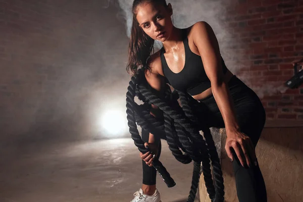 Mujer atractiva fuerte con cuerda de batalla en el gimnasio —  Fotos de Stock