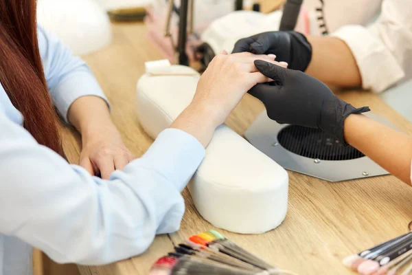 Cuidado maestro de la manicura en guantes negros comienzan a hacer manicura —  Fotos de Stock