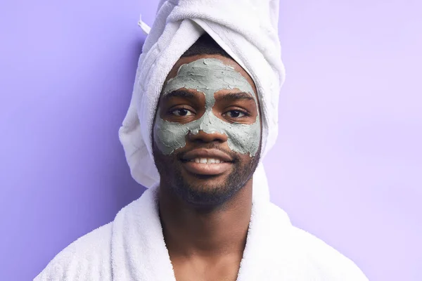 Retrato de belleza de un hombre africano guapo de pie aislado sobre fondo púrpura en máscara de belleza —  Fotos de Stock