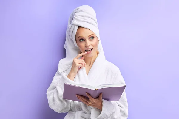 Retrato de jovem livro de leitura do sexo feminino, isolado em fundo roxo — Fotografia de Stock