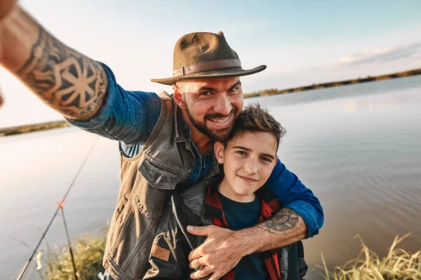 La primera pesca conjunta de padre adulto e hijo adolescente en un día cálido y soleado . —  Fotos de Stock