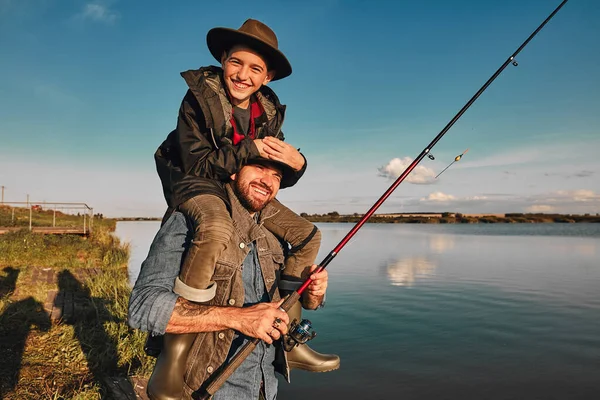 The first joint fishing of adult father and teen son in warm, sunny day. — Stock Photo, Image