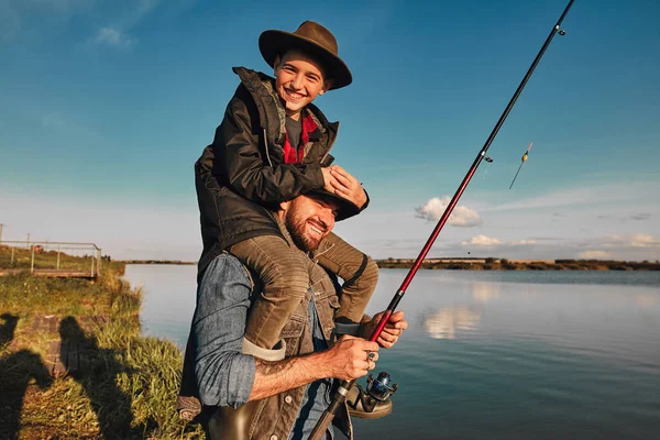 La primera pesca conjunta de padre adulto e hijo adolescente en un día cálido y soleado . — Foto de Stock