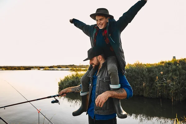 La primera pesca conjunta de padre adulto e hijo adolescente en un día cálido y soleado . — Foto de Stock