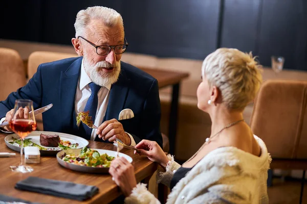 Όμορφη κυρία και ηλικιωμένος άνδρας έχουν φιλική συνομιλία στο εστιατόριο — Φωτογραφία Αρχείου