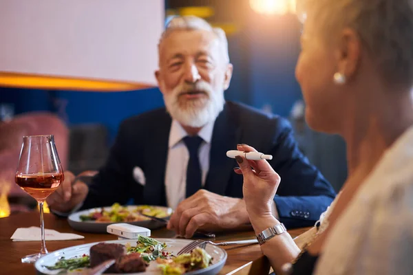 Senior pareja caucásica tener conversación sobre multa comida en restaurante — Foto de Stock