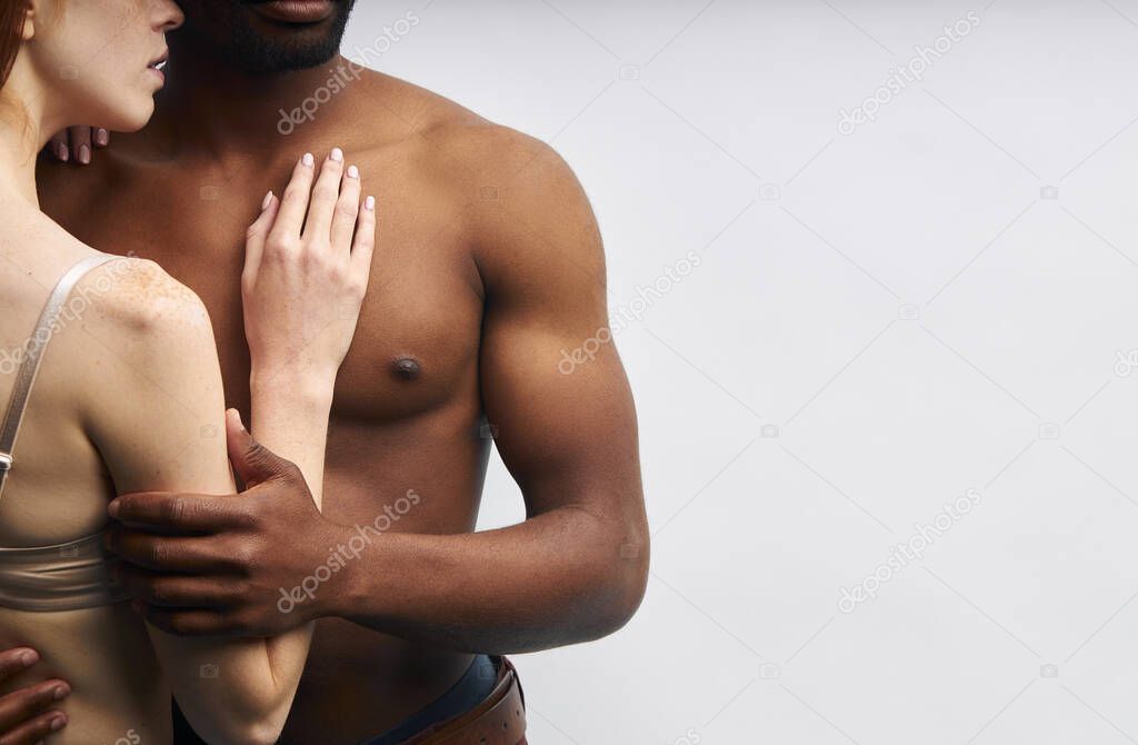 Cropped interracial couple on white background