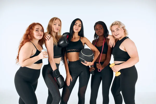 Портрет пяти улыбающихся мультиэтнических женщин в черной спортивной одежде — стоковое фото