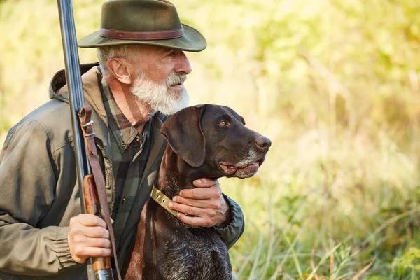 Senior jägare med hund i skogen — Stockfoto