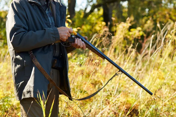 Hunter laddar geväret i höstskogen — Stockfoto