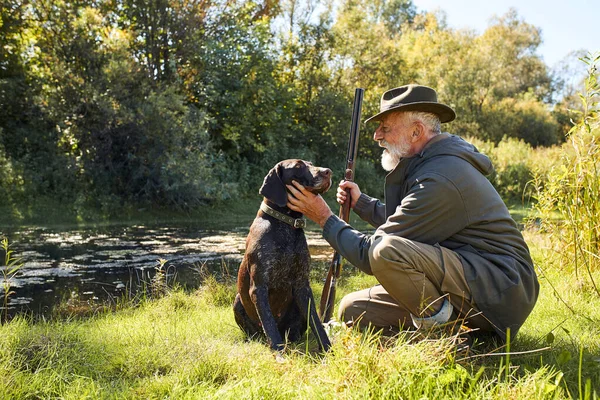 Hunter e seu cão fazem uma pausa na floresta — Fotografia de Stock