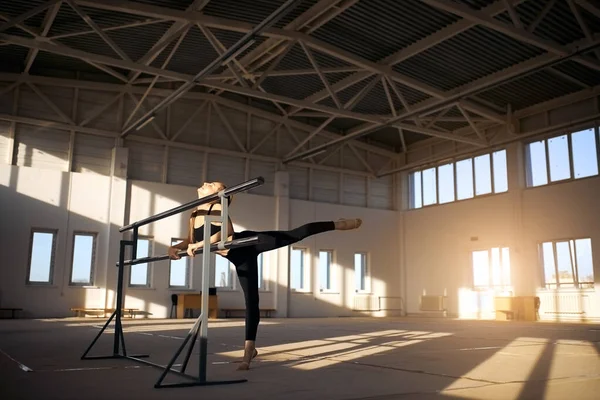 Genç bayan jimnastikçi spor salonunda akrobatik egzersiz yapıyor. — Stok fotoğraf