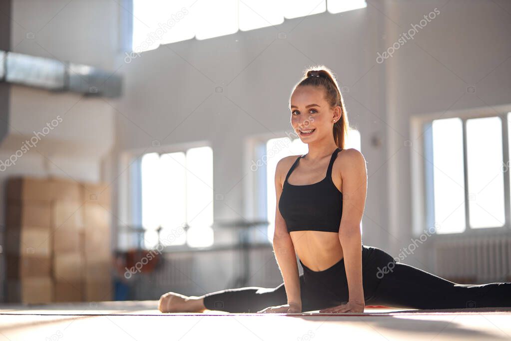 Gymnast girl doing splits in studio