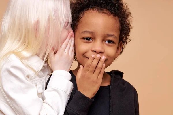 Överraskad afro pojke och positiv albino flicka har hemlighet — Stockfoto