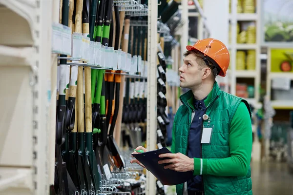 Trabalhador armazém conta o número de pás na loja — Fotografia de Stock