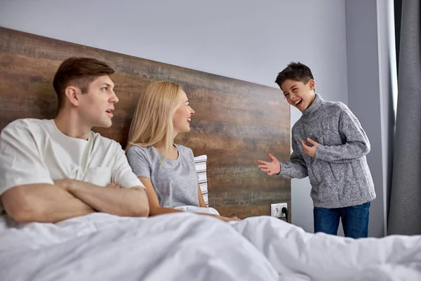 Boldog kaukázusi szum beszélgetés a szülők az ágyban — Stock Fotó