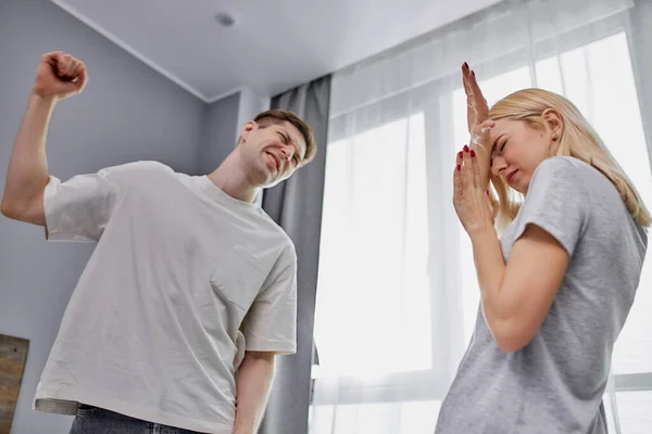 Cruel man swings his fists at a defenseless wife — Stock Photo, Image