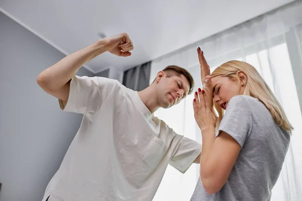 Cruel man swings his fists at a defenseless wife — Stock Photo, Image