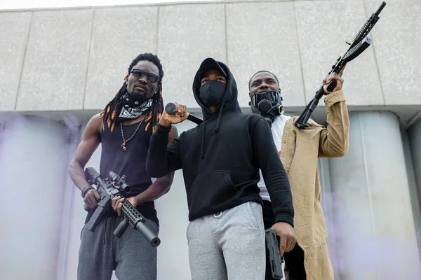 three black men with guns ready to shoot if discrimination does not stop