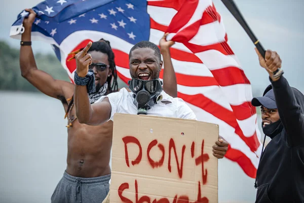 Black lives matter protests go global. three afroamerican people with posters in the street