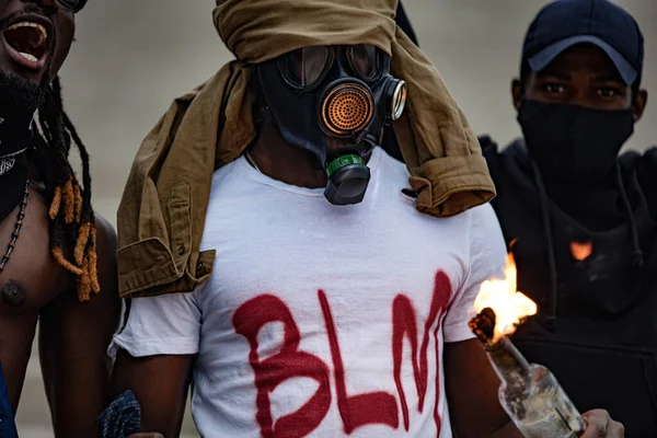 Афроамериканцы держат в руках горящую стеклянную бутылку — стоковое фото