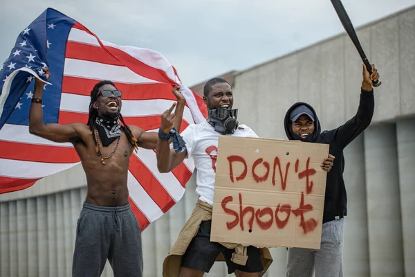 Le proteste per le vite dei neri diventano globali. tre afroamericani con manifesti in strada — Foto Stock