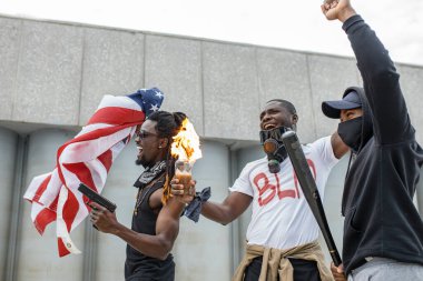 Saldırgan Afro-Amerikan erkekleri gösteri sırasında sokaklarda şişeleri ateşe verdiler.