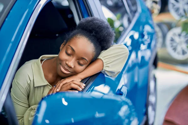 Bella signora africana piaciuto automobile in auto showroom — Foto Stock