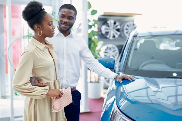 Schöner Afro-Mann zeigt Frau ein Auto, das ihm gefällt — Stockfoto