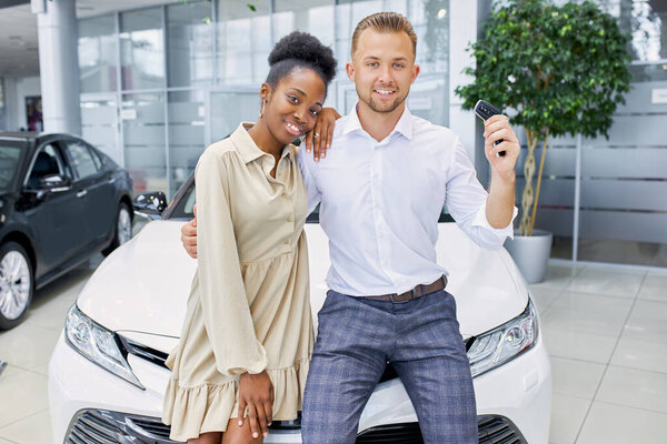 привлекательная женщина и красивый парень доволен покупкой в дилерском центре
